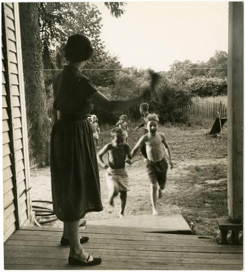 Mother ringing bell for children to come inside