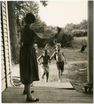 Mother ringing bell for children to come inside