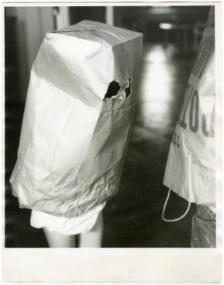 Two children playing as ghosts covered with paper bags