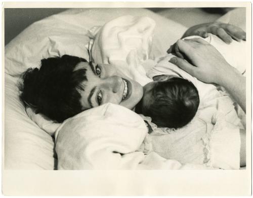 Portrait of mother in bed cradling infant