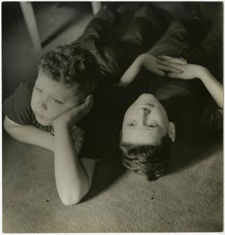 Portrait of two boys lying on carpeted floor