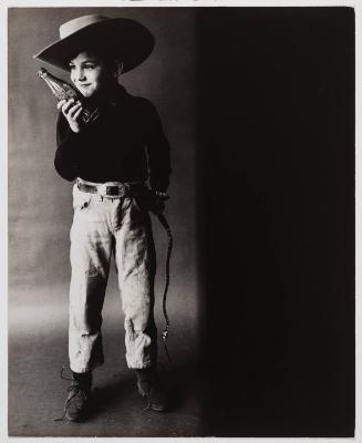 Advertising photograph of boy dressed as cowboy with a Coca-Cola