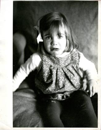 [Portrait of crying young girl wearing hair bow]