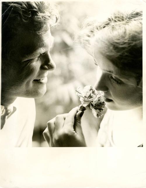 [Portrait of father smiling at daughter holding a flower]