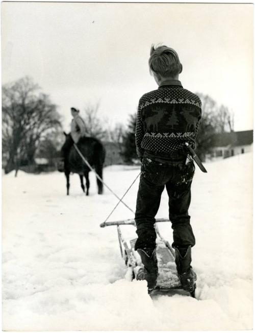 [Farm boy on sled being pulled by horse]