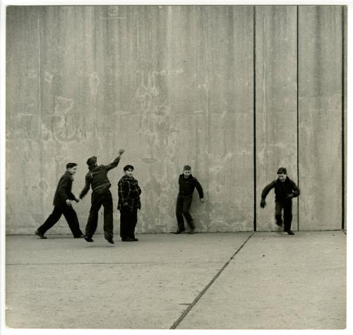 [NYC boy playing with friends in empty court]