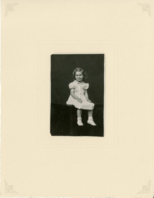 Smiling girl seated on table