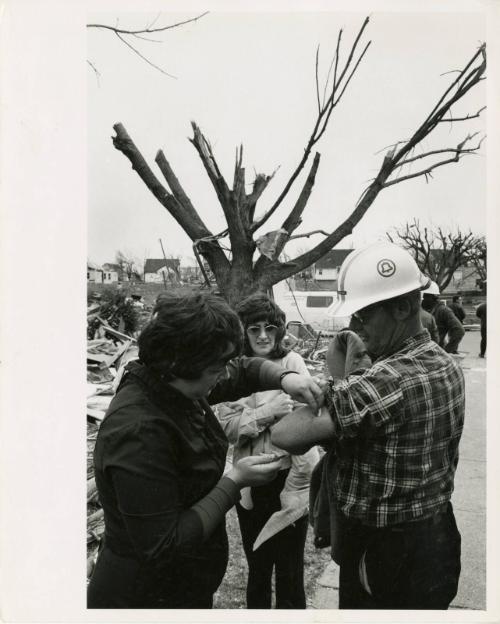 Worker receiving medical care outside homes damaged by tornado, Xenia, OH, USA