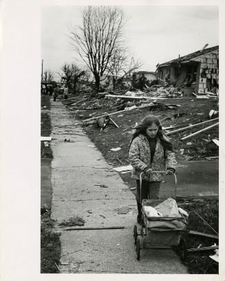 [Girl pushes cart outside homes damaged by tornado, Xenia, OH, USA]