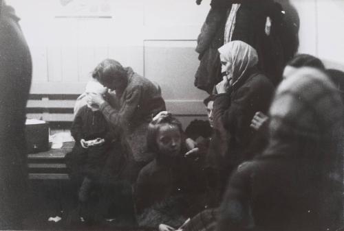 Gathering, with woman tending to child, Poland