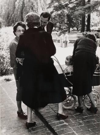 Women and baby carriage in a park