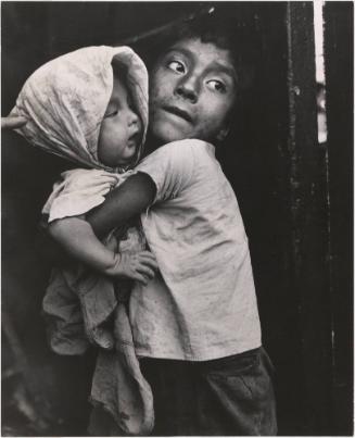 Boy holding an infant in a head scarf, El Salvador