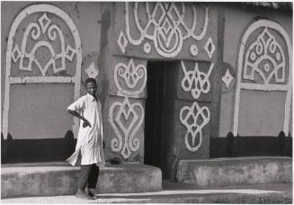 A young man standing in front of his highly decorated family house, Bauchi, Nigeria