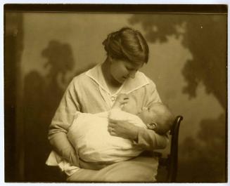 Portrait of mother smiling at baby in her arms