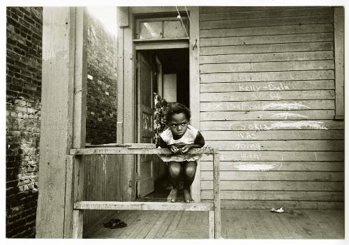 Newark Essay [scowling girl on porch railing]