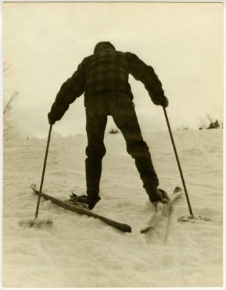 Farm boy on skis walking uphill