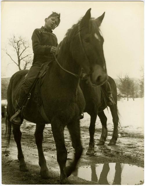 Farm boy riding horse through muddy trail and snow