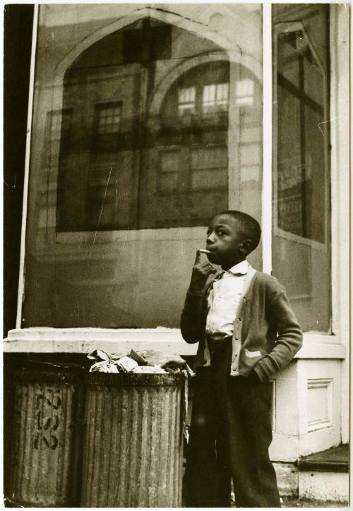 Negro boy smoking a cigarette in front of a store front church in Brooklyn