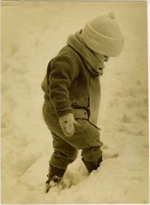 Portrait of bundled up young child playing in snow