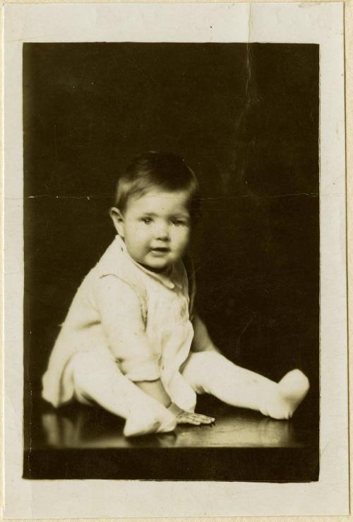 Infant seated on table