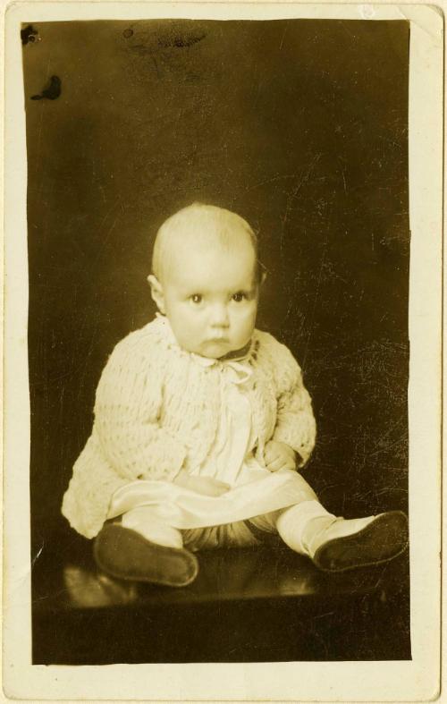 Infant with intense gaze seated on table