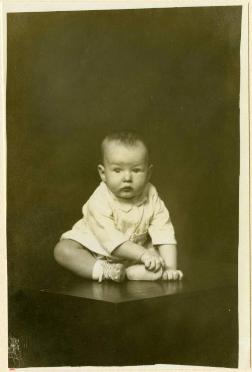 Infant seated on table