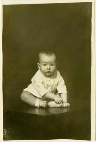 Infant seated on table