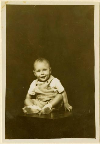 Happy infant seated on table