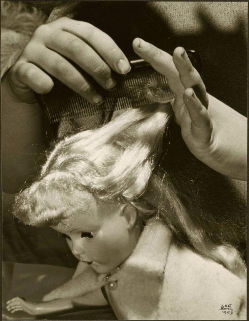 Study of girl's hands combing doll's hair