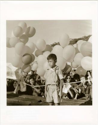 Boy with balloons at political rally, Indonesia