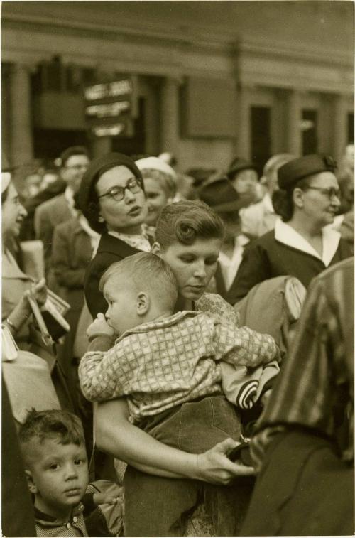 Woman holding child while standing in line