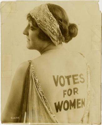 Pretty Advocate of “Votes for Women” Creates Sensation with Plea for Cause Painted on Her Charming Back
