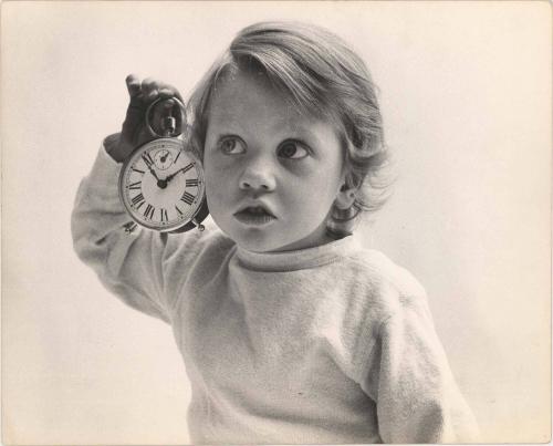 Portrait of toddler holding alarm clock