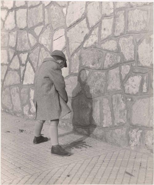 Boy releasing himself against the wall, Italy