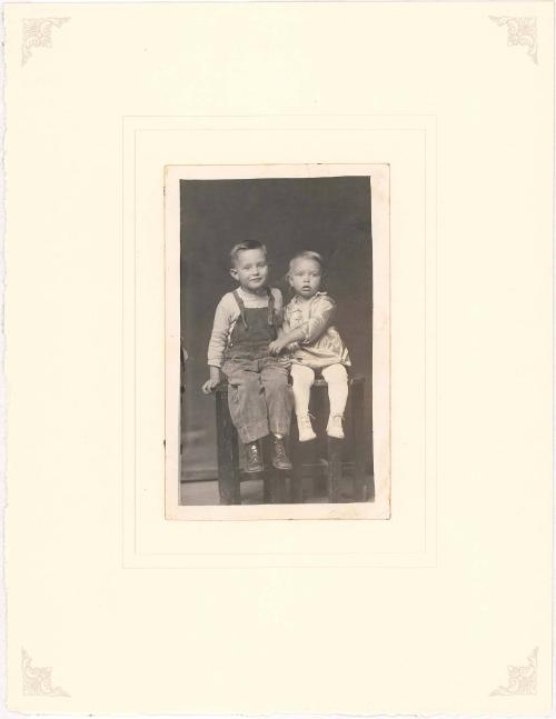 Brother and sister seated on table