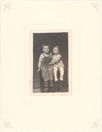 Brother and sister seated on table