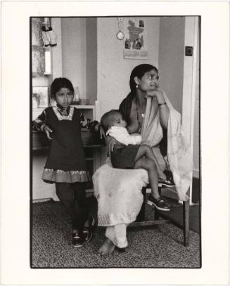 Mother breastfeeding child, London