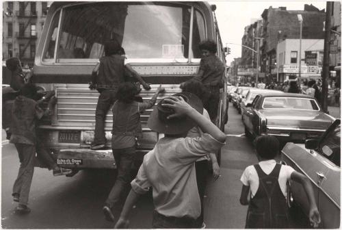 Kids climbing on the back of a bus, New York City