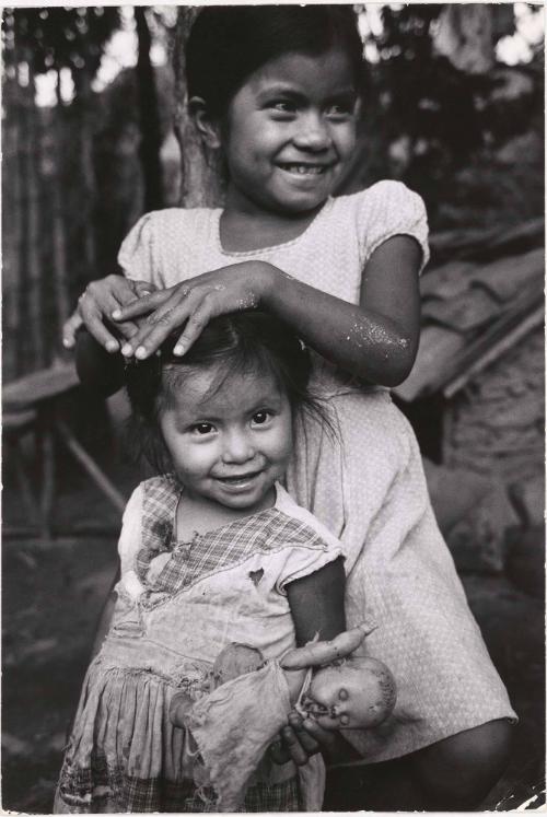 One girl grooming another girl’s hair, El Salvador