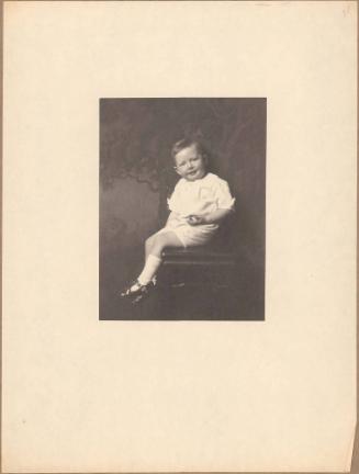 Portrait of smiling toddler in white stockings seated