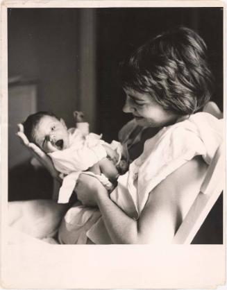 Portrait of mother smiling at infant in her arms