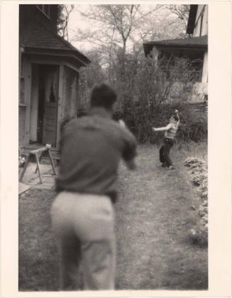 Boy with glasses and father playing catch in backyard from the series Big Brother