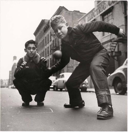 NYC boy playing ball with friend in street