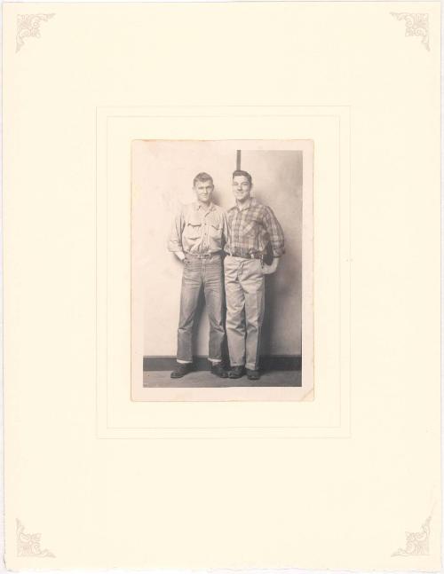 Two young men standing, striped background