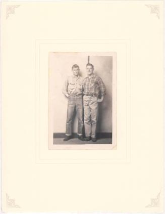 Two young men standing, striped background