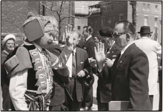 Man in costume greeting man in suit, Quebec