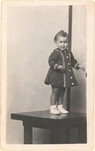 Girl standing on table, striped background