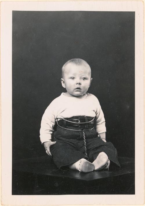 Seated infant in restraining device