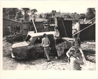 [Children Play amongst Rubble and Destroyed Car, Londonderry, Northern Ireland]