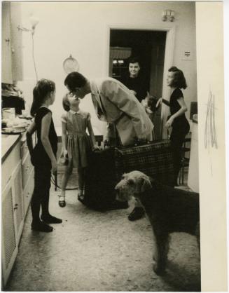 Father kissing daughter after arriving home from a trip